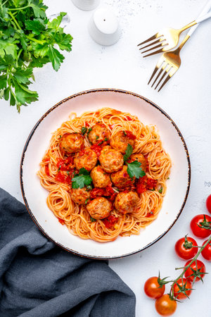 Spaghetti with meatballs in marinara sauce, top view, white tableの写真素材