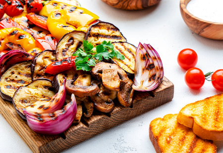 Summer vegan BBQ appetizer with paprika, eggplant, tomatoes, zucchini, onions and mushrooms, white background, top viewの写真素材