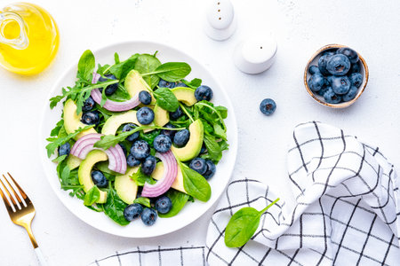 Megan salad with blueberry, avocado, onion, spinach and arugula, white background, top viewの写真素材