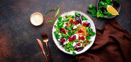 Foodie food salad with beetroot, ricotta and tangerine with lettuce, onion. Brown background. Top viewの写真素材