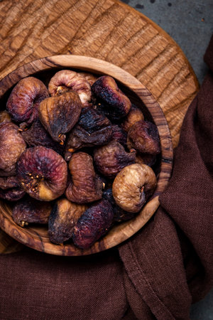 Sun dried figs in bowl on brown background, top viewの写真素材