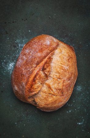 Rustic whole grain wheat sourdough bread. Green table background, top viewの写真素材
