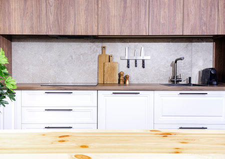 Cozy white and wood kitchen interior with wooden table, modern classic, with induction hob, black...