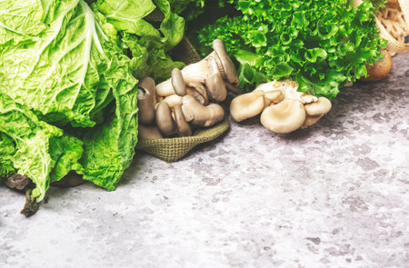 Fresh Food Background. Eco string bag with green vegetables, broccoli, avocado, mushrooms and other on gray table, top viewの写真素材