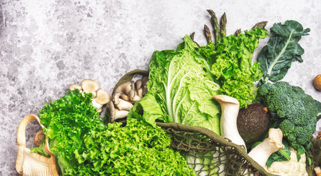 Fresh Food Background. Eco string bag with green vegetables, broccoli, avocado, mushrooms and other...