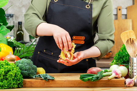 Cook collects peeling potatoes for compost. Cozy kitchen with wooden table, kitchenware, vegetables,...