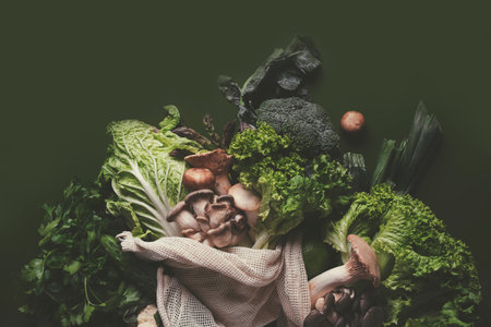 Vibrant green vegetables and fresh herbs are arranged in a reusable storage bag, ready for cooking nutritious meals from the farmer's market.の写真素材