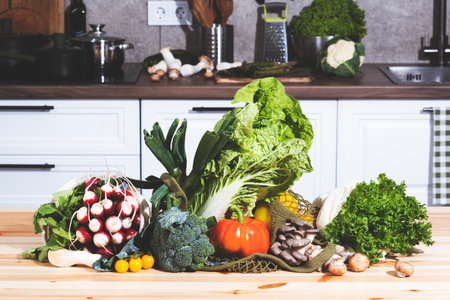 Fresh vegetables and herbs fill an eco-friendly bag on a kitchen table, showcasing the bounty from a farmer's market for cooking nutritious meals.の写真素材