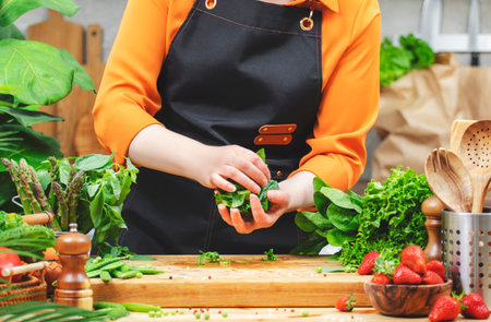 Healthy vegan cooking in a vibrant kitchen with fresh vegetables and a passionate chef preparing a delightful dishの写真素材