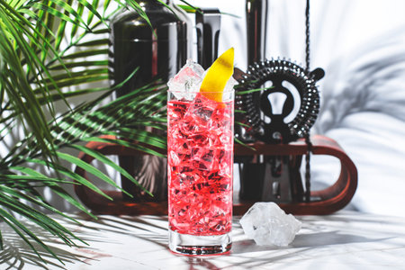 Refreshing cocktail pink served over ice with a lemon garnish in a tropical settingの写真素材