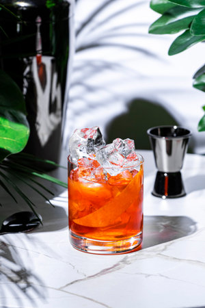 Non-alcoholic negroni mocktail with ice served in a stylish bar settingの写真素材