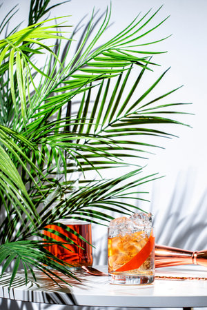 Vibrant cocktail creation featuring vodka aquavit, Italian aperitif, and scotch whiskey with a grapefruit twist on a stylish tableの写真素材