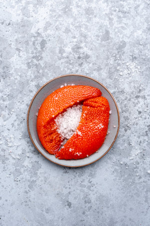 Fresh whole raw red caviar extracted from live trout or salmon with sea salt, gray background, top...