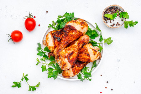 Baked chicken legs or stick drums, white table background, top viewの写真素材
