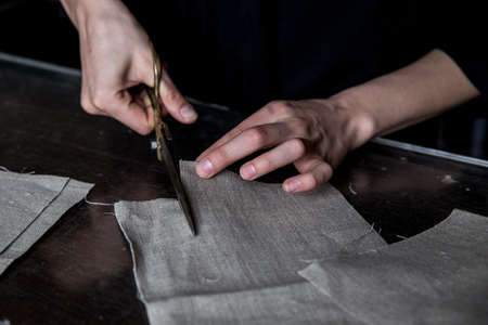 Cutting linen fabric using brass scissorsの写真素材