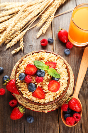 Oatmeal with berries on brown wooden backgroundの写真素材