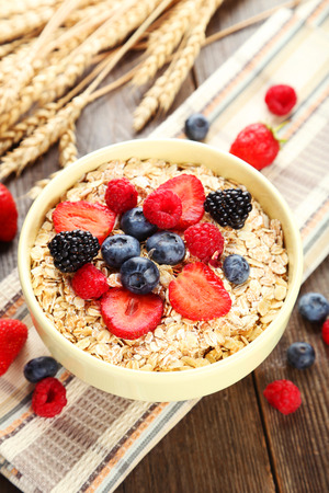 Oatmeal with berries on brown wooden backgroundの写真素材