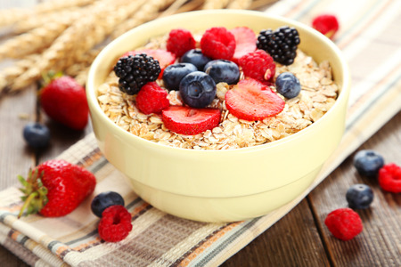 Oatmeal with berries on brown wooden backgroundの写真素材