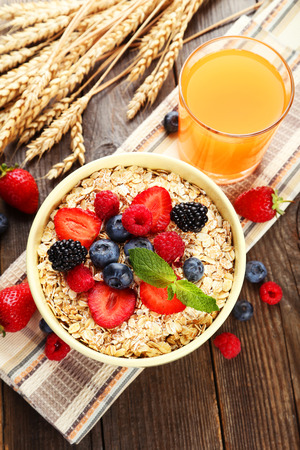 Oatmeal with berries on brown wooden backgroundの写真素材