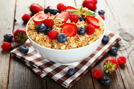 Oatmeal with berries on brown wooden backgroundの写真素材