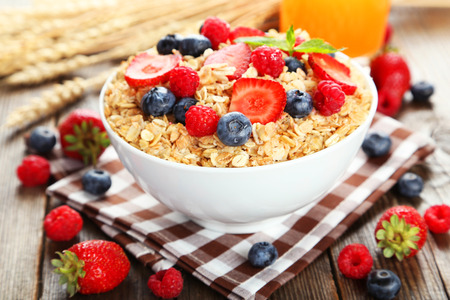 Oatmeal with berries on brown wooden backgroundの写真素材