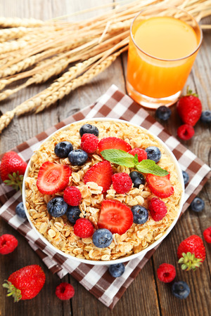 Oatmeal with berries on brown wooden backgroundの写真素材