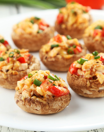 Stuffed mushrooms on plate on white wooden backgroundの写真素材