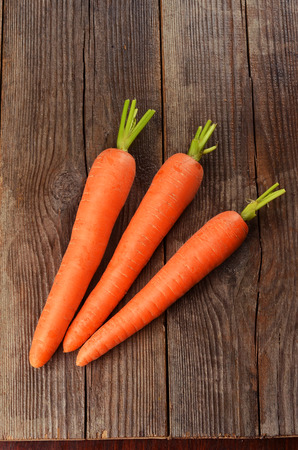 Fresh carrots on brown wooden backgroundの写真素材