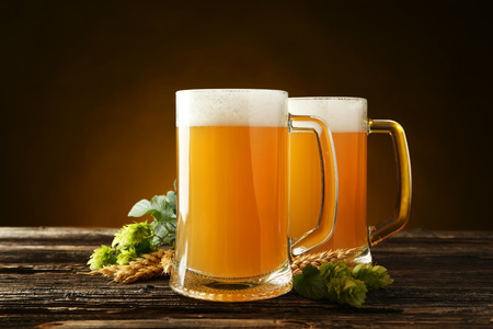 Mug of beer on a brown wooden backgroundの写真素材
