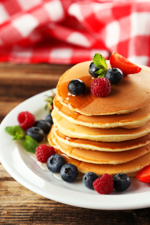 Delicious pancakes with berries on brown wooden backgroundの写真素材