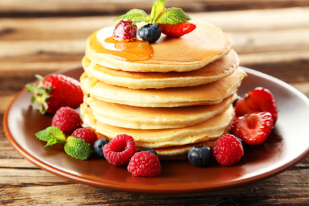 Delicious pancakes with berries on brown wooden backgroundの写真素材