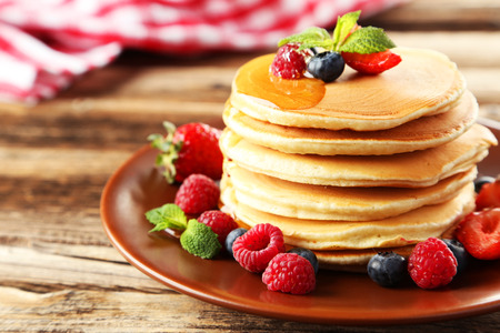 Delicious pancakes with berries on brown wooden backgroundの写真素材