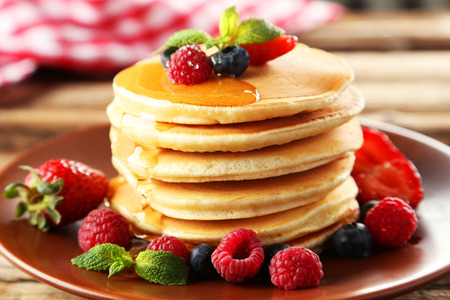 Delicious pancakes with berries on brown wooden の写真素材