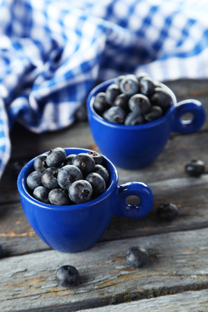 Blueberries in cup on blue wooden の写真素材
