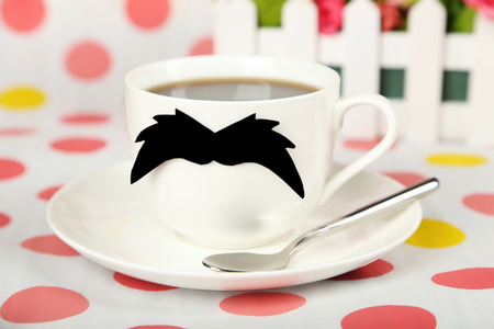 White cup with paper mustache on colorful backgroundの写真素材