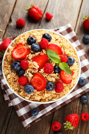 Oatmeal with berries on brown wooden の写真素材