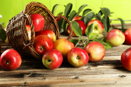 Apples in basket on brown wooden backgroundの写真素材