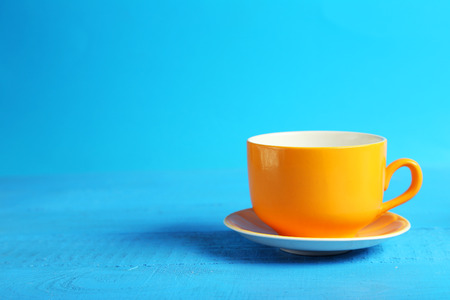 Orange cup on blue wooden backgroundの写真素材