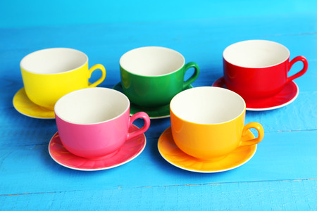 Colorful cups on blue wooden backgroundの写真素材