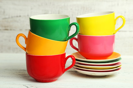 Colorful cups on white wooden backgroundの写真素材