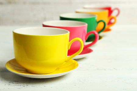 Colorful cups on white wooden backgroundの写真素材