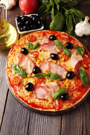 Delicious fresh pizza on brown wooden backgroundの写真素材