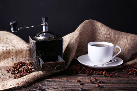 Coffee grinder with coffee beans on brown wooden backgroundの写真素材
