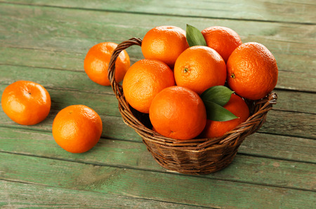 Mandarin in basket on green wooden backgroundの写真素材