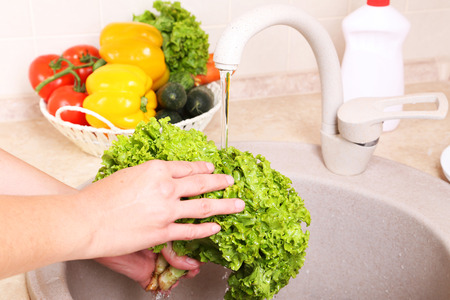 Vegetables washing in kitchen の写真素材