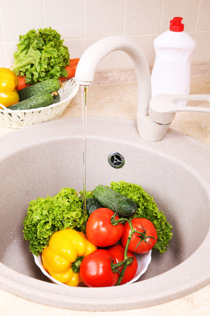 Vegetables washing in kitchenの写真素材