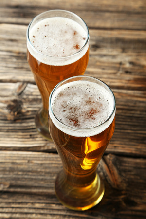 Two glass of beer on brown wooden backgroundの写真素材