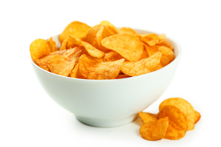 Potato chips in bowl isolated on whiteの写真素材