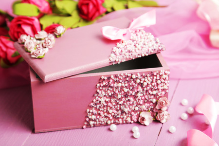 Beautiful casket with flowers on purple wooden backgroundの写真素材