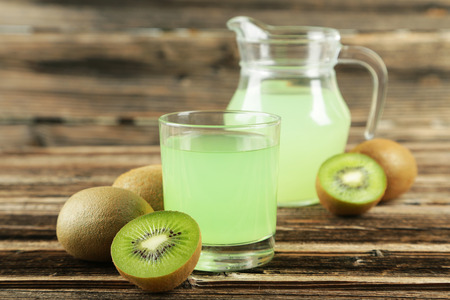 Fresh juice with kiwi on brown wooden backgroundの写真素材